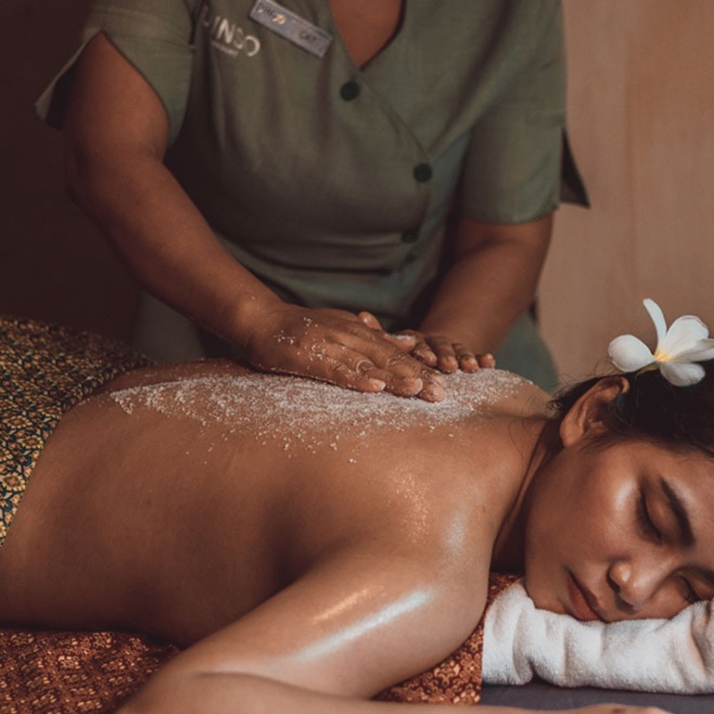 Spa therapist applying a salt scrub on a woman’s back at JAMUNA Spa in Dinso Resort Phuket