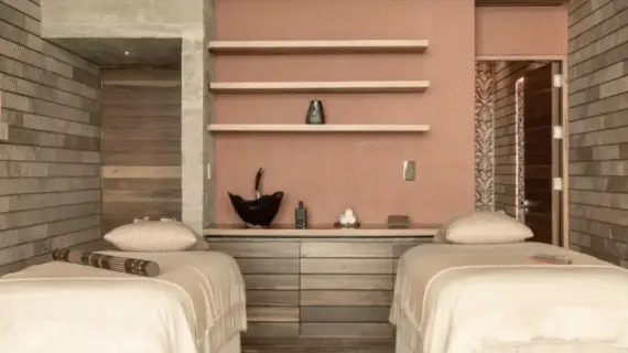 Peaceful spa room with dual massage beds, earthy tones, and artisanal decor designed for relaxation and connection.