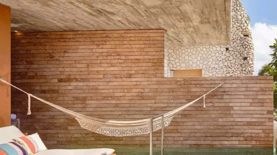 Oceanview suite featuring a stone pool, lounge chair, and hammock surrounded by tropical greenery.