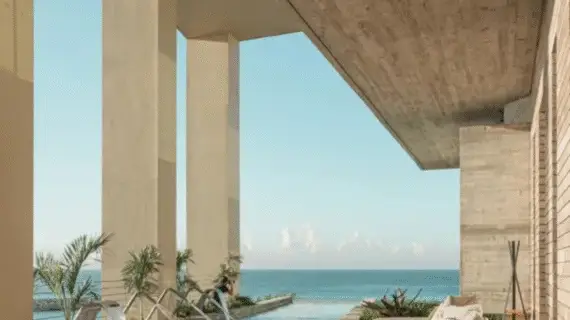 Elegant spa pool with hydromassage jets set against tall modern columns overlooking the sea.