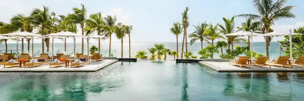Main pool at Hotel Mousai Cancun with lounge chairs and umbrellas