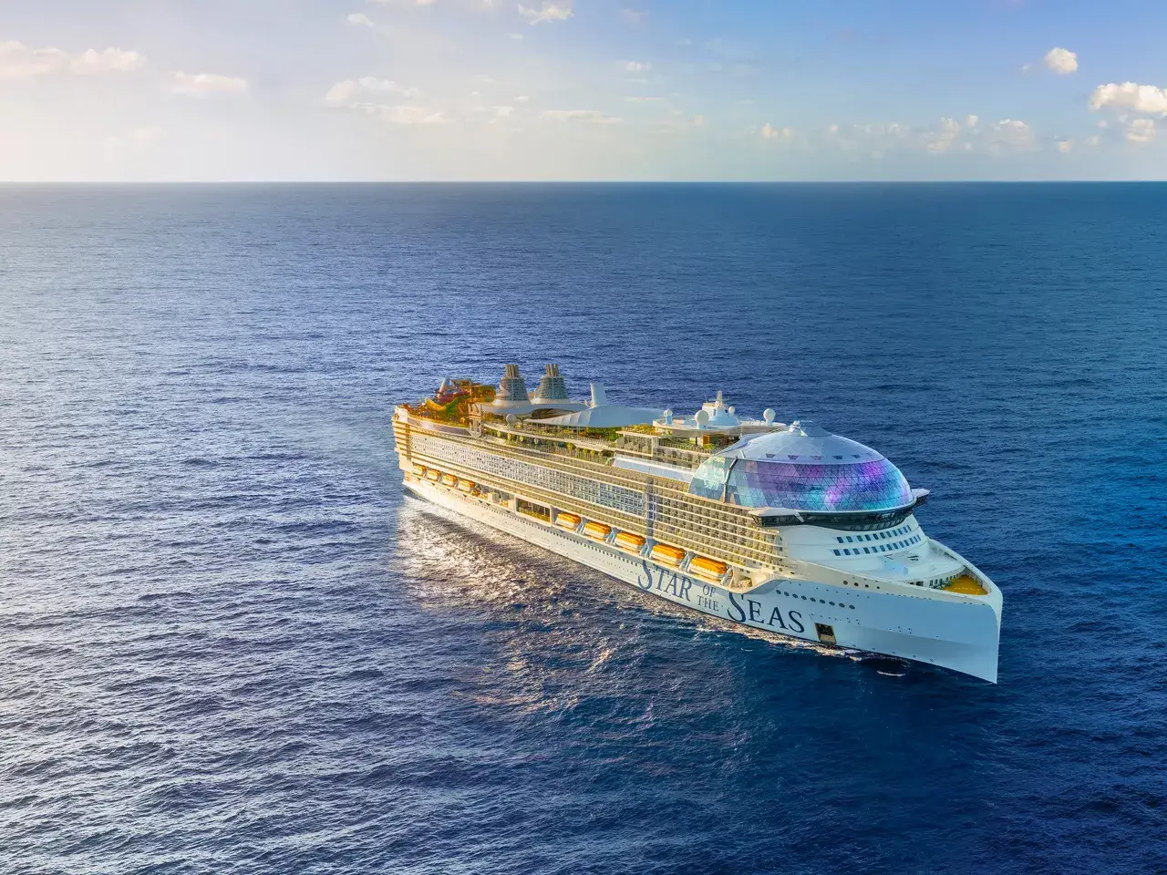 Modern luxury cruise ship sailing through open ocean under clear skies