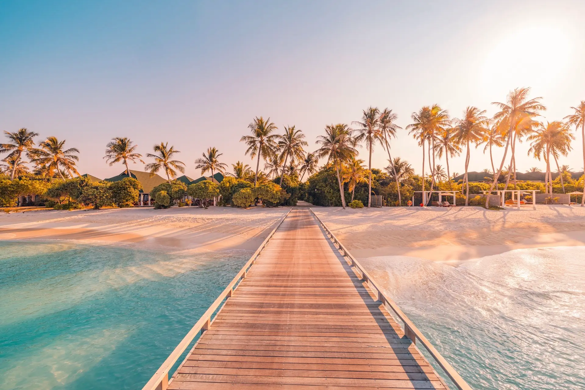 Ultra luxury vacations arrival experience at a private island resort with a wooden pier and palm trees